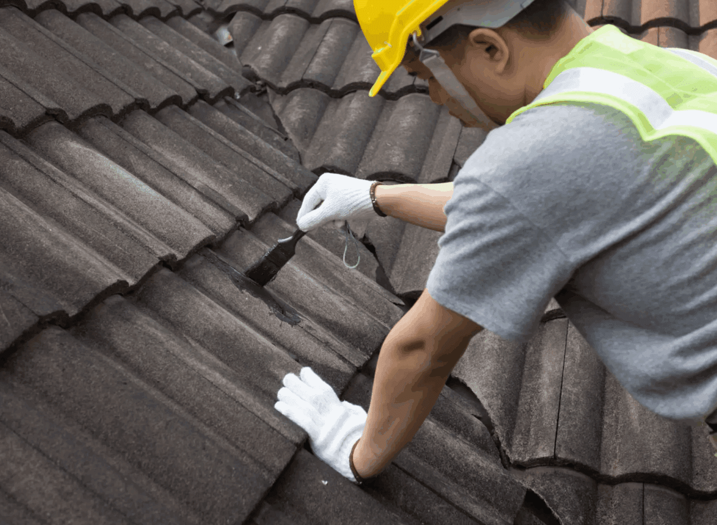 Worker repairing roof with brush