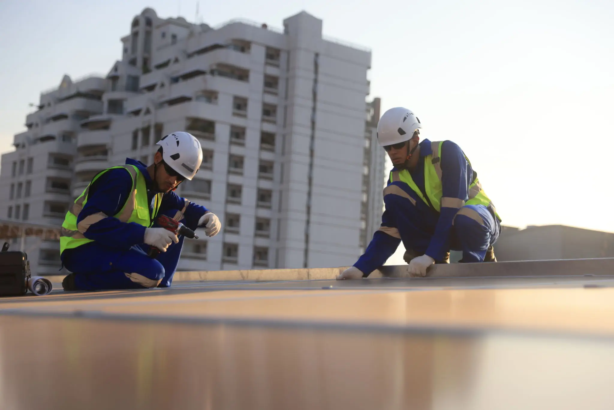 Workers installing solar panels on rooftop.