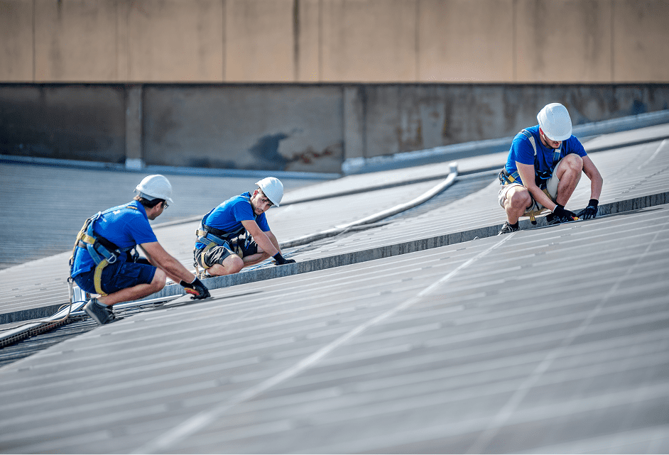 Construction workers securing rooftop cables